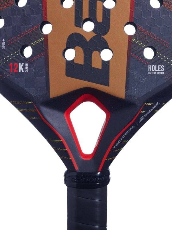 Eine Detailansicht des Babolat Technical Viper 2024 Padelschlägers hebt seine aufwendig gemusterte Oberfläche mit strategisch platzierten Perforationen hervor. Die Begriffe „12K Carbon“, „Holes Pattern System“ und das ikonische „Babolat“-Logo sind deutlich sichtbar. Dieser Schläger verfügt über einen schwarzen Griff und eine auffällige Farbpalette aus Rot und Orange, die für hohe Leistungsfähigkeit steht.