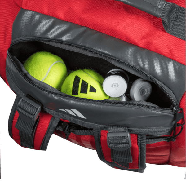 Eine Adidas Tour 3.3 Solar Rot Padeltasche-Sporttasche mit einer teilweise geöffneten Reißverschlusstasche zeigt zwei gelbe Tennisbälle und zwei Dosen mit Tennisbällen und zeigt so eine übersichtliche Aufbewahrungslösung.