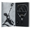 Ein schwarzer Adidas Metalbone Pro EDT 2024 Padelschläger liegt in einer offenen Box, deren Deckel ein Graustufenbild eines Athleten in Aktion auf dem Padelplatz zeigt, das den Geist des Sports einfängt. Neben dem Schläger finden Sie ein praktisches Werkzeug, das Ihr Spielerlebnis verbessern soll.