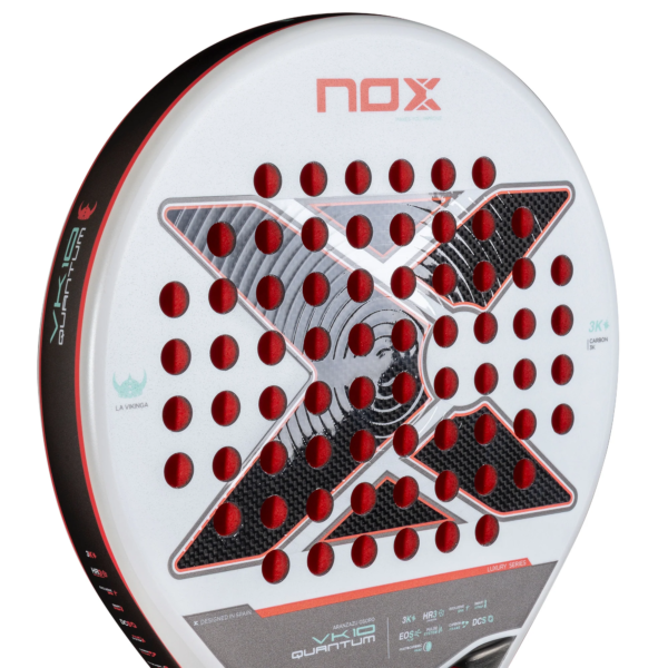 Nahaufnahme des NOX VK10 QUANTUM 3K Padelschlägers von Aranzazu Osoro. Es handelt sich um einen weißen Paddle-Tennisschläger mit einem leuchtend roten „X“-Design, kreisförmigen Ausschnitten und schwarzen Akzenten. Der Griff ist mit Text und Logos verziert, was sein elegantes und modernes Aussehen unterstreicht.